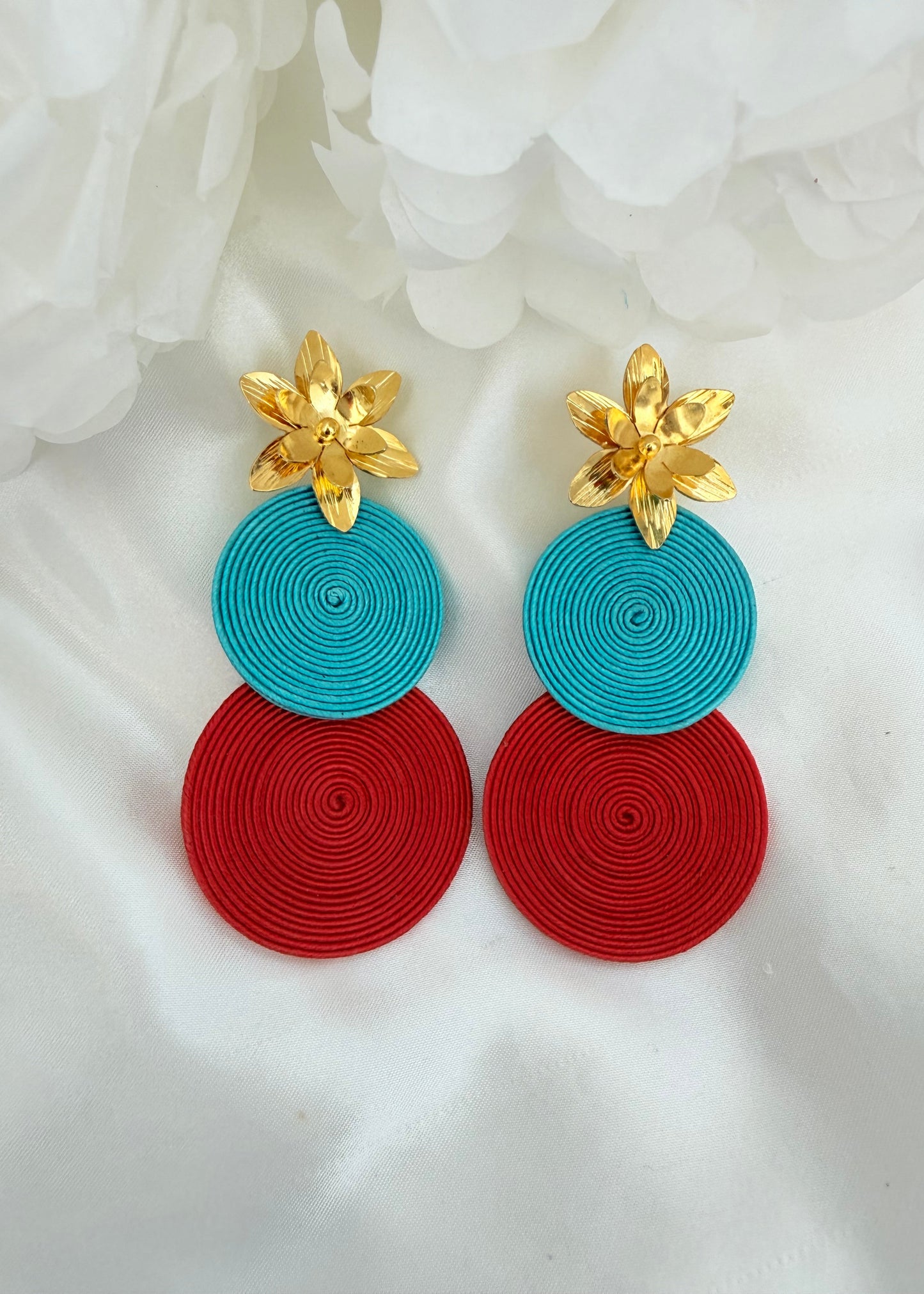 Primer plano de los aretes Macarena soutache mostrando el detalle del lirio bañado en oro