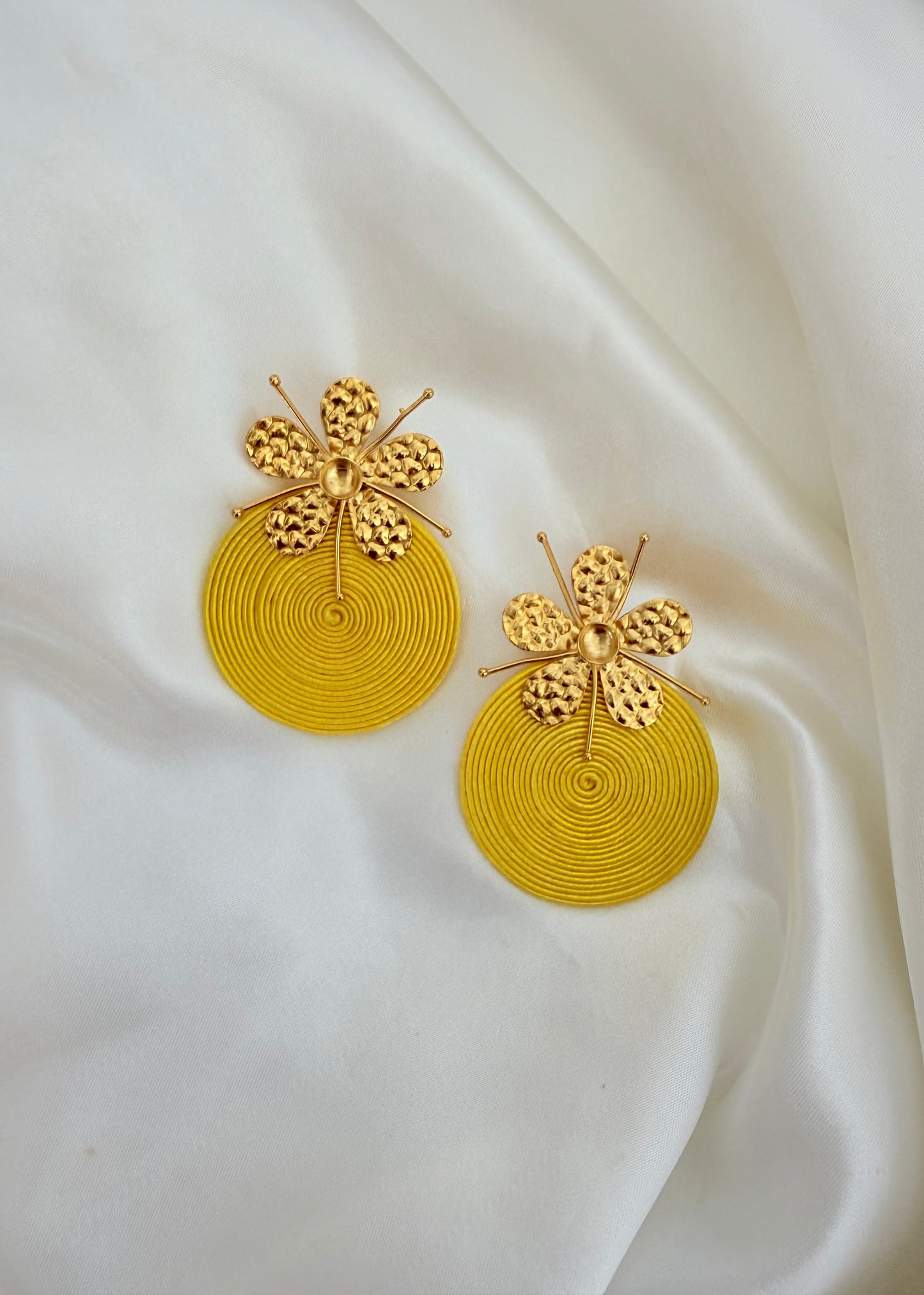 Primer plano de los aretes Florida mostrando el detalle de la flor bañada en oro 24k
